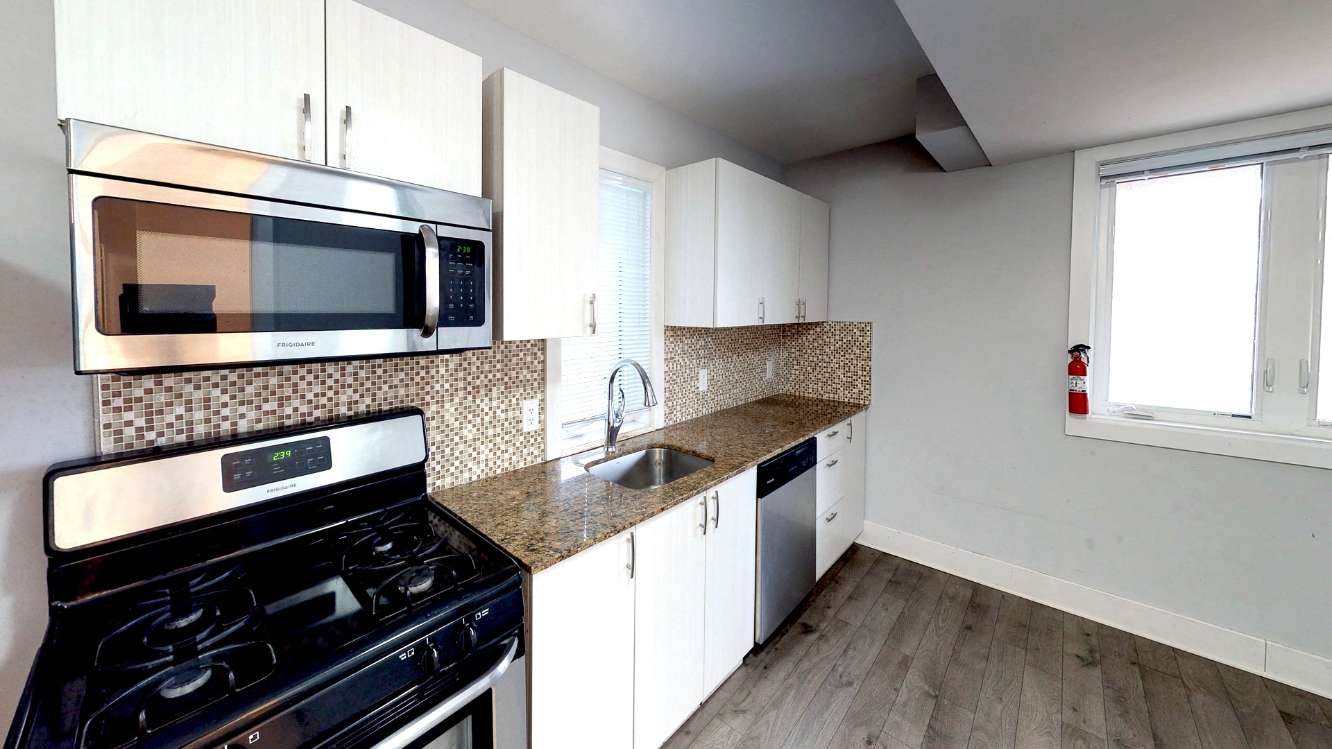 a kitchen with white cabinets and a stove and a microwave
